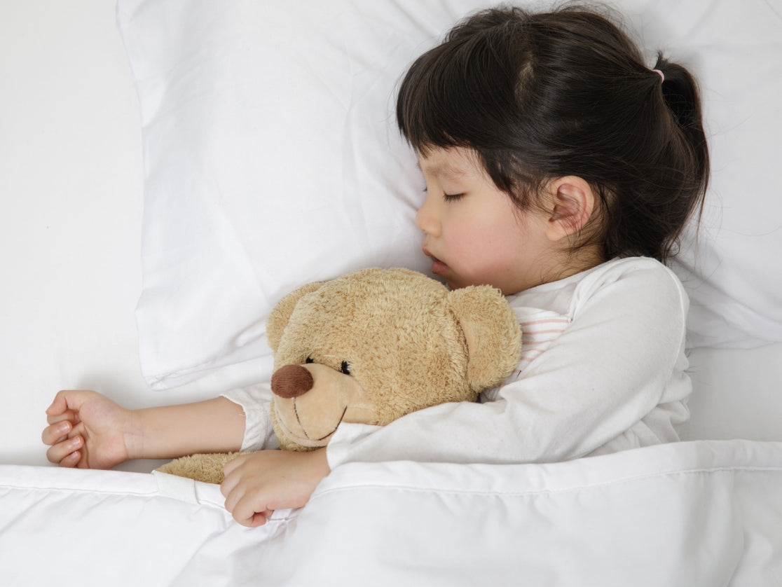 child sleeping with a teddy bear